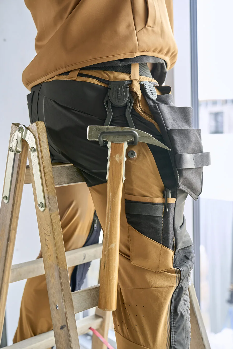 Handwerker mit Hammer in Mascot Arbeitshose
